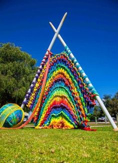 1 photo d'une réalisation en laine géante représentant une pelote de laine et d'un tricot en cours